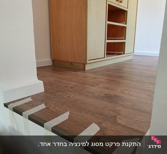רצפת פרקט חומה עם סרטי הדבקה על הקצה